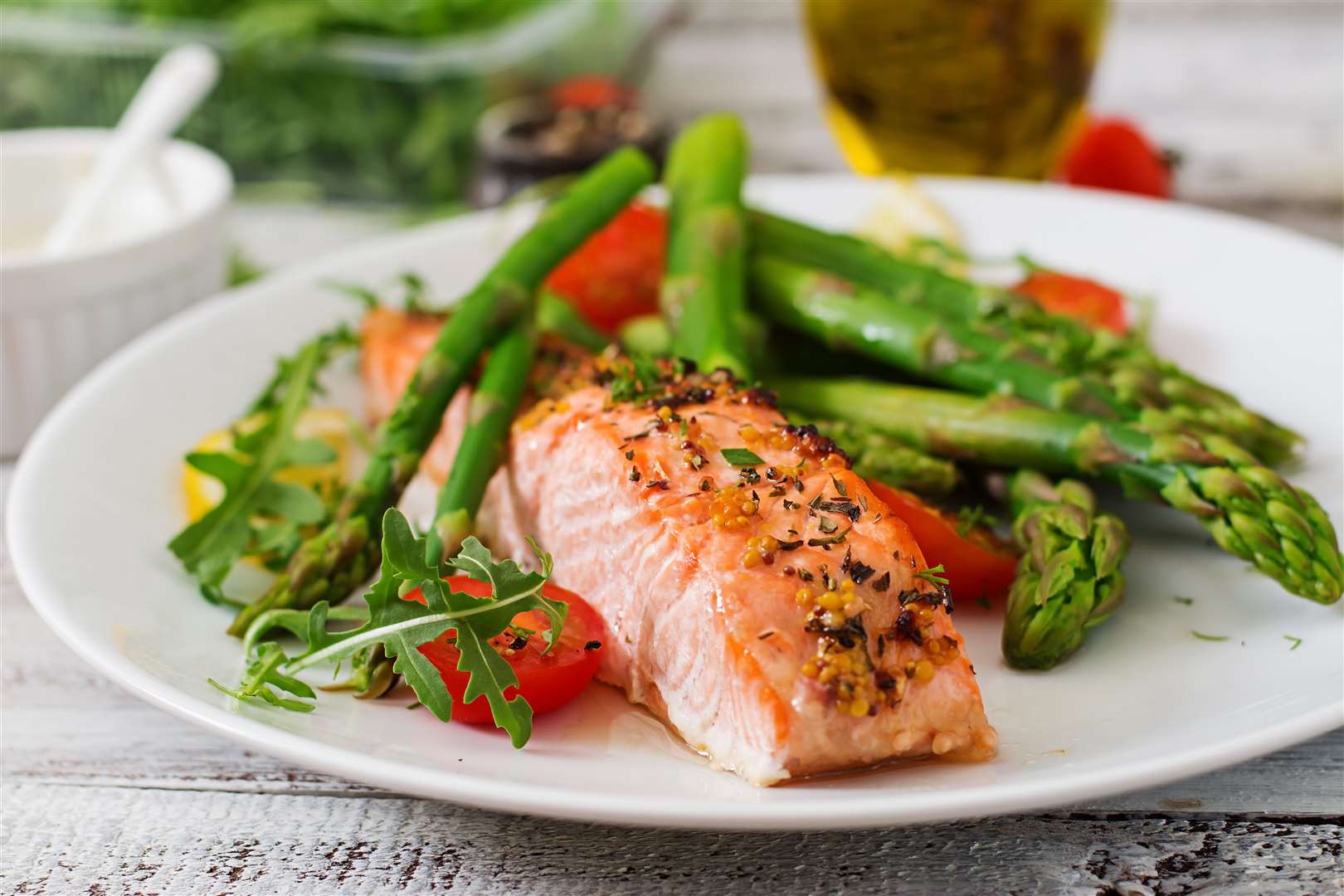 Baked salmon garnished with asparagus and tomatoes with herbs. (34777005)